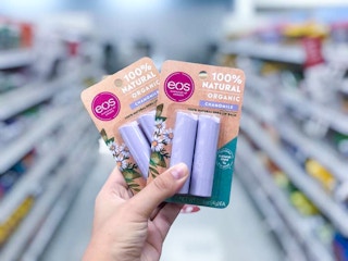 hand holding 2 packs of eos lip balm at target