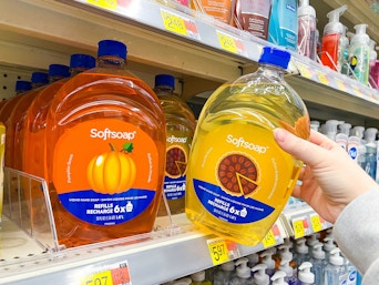 hand holding softsoap refill next to another on walmart shelf