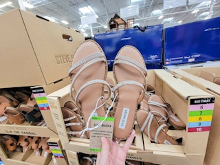 hand holding a pair of tan with silver sparkles ladies sandals