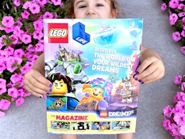child holding the lego life magazine outside
