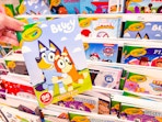 hand holding a crayola coloring book in front of a target shelf