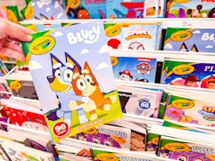 hand holding a crayola coloring book in front of a target shelf