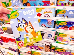 hand holding a crayola coloring book in front of a target shelf