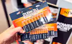 hand holding two packs of duracell batteries
