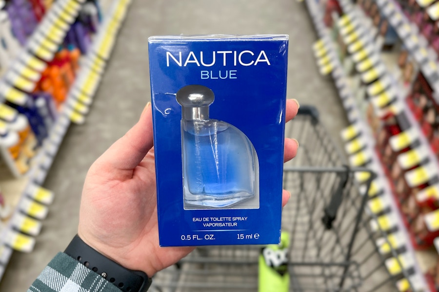 person holding a nautica fragrance over a cart