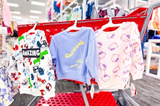 toddler sweatshirts in hello kitty, spiderman, and california designs hanging off the side of a target cart