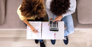 overhead view of couple on couch going through finances
