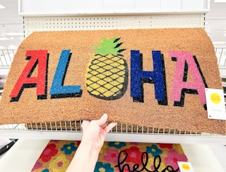hand holding aloha summer doormat at target