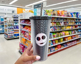 hand holding Nightmare before Christmas studded tumbler in aisle