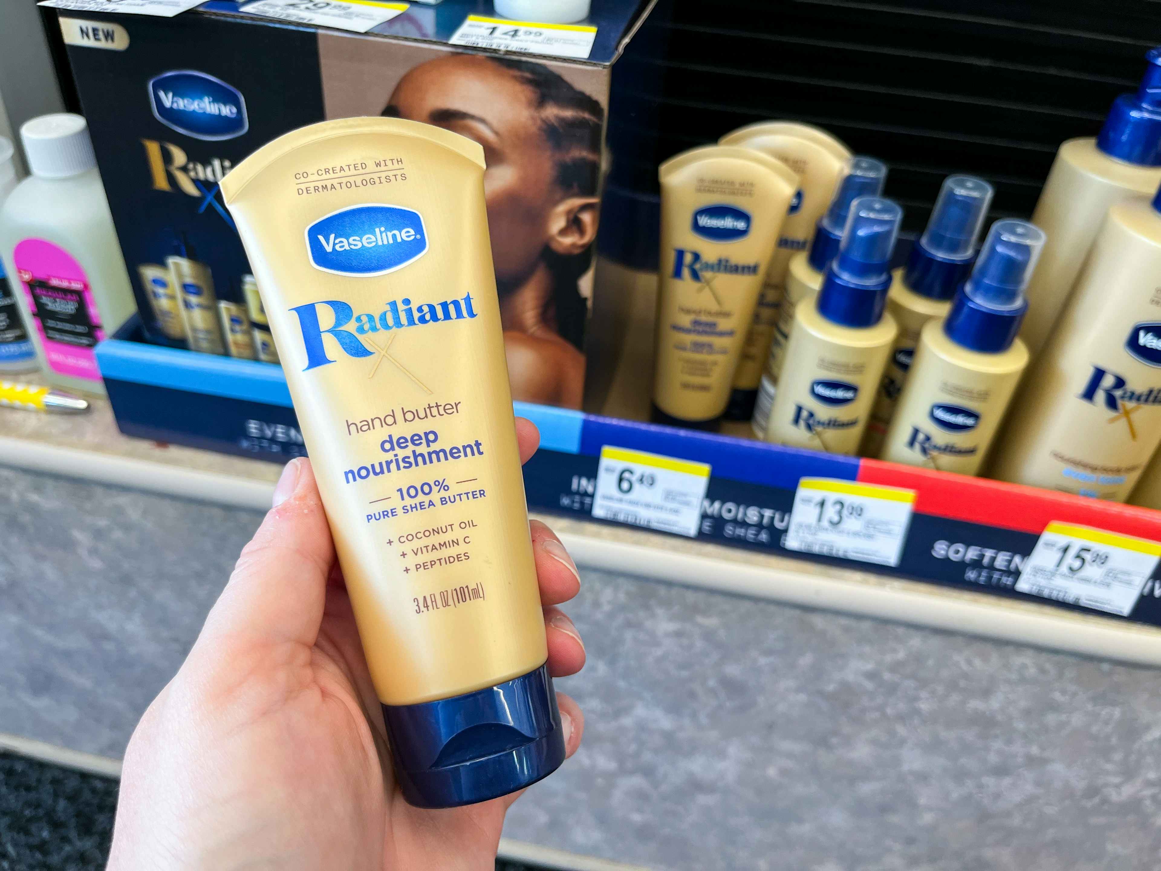 hand holding lotion in front of vaseline radiance store display