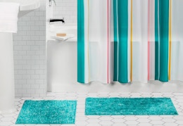 shower curtain and two teal colored rugs
