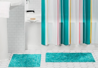 shower curtain and two teal colored rugs