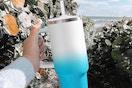a woman holding a tumbler