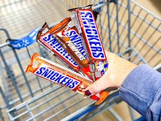 4 Snickers candy bars held up over Walmart shopping cart