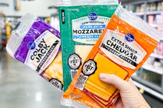 hand holding packs of kroger cheese slices