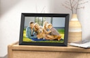 A picture frame with a family photo on a wooden dresser