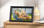 A picture frame with a family photo on a wooden dresser