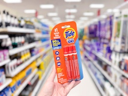hand holding a pack of tide stain remover to go pens in a target aisle