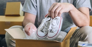 A person packing some shoes to ship