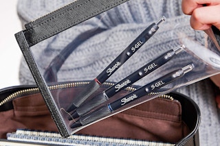 a clear bag with three pens 