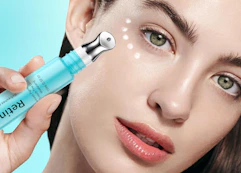 a person holding a tube of eye cream