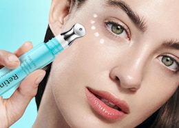 a person holding a tube of eye cream