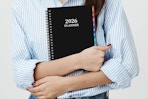 a woman holding a 2026 planner