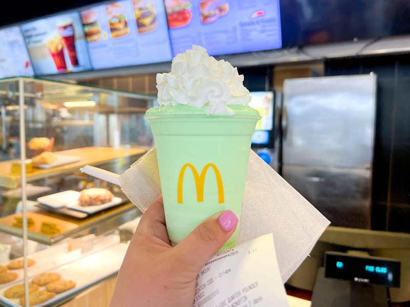 hand holding mcdonalds shamrock shake and receipt at register