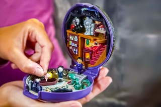Lifestyle image: close up of hands playing with the The Addams Family Polly Pocket Collector Toy