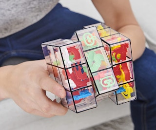 a person playing a rubiks cube toy