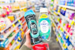 person holding downy scent beads and fabric rinse in an aisle