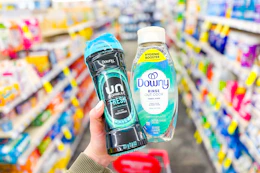 person holding downy scent beads and fabric rinse in an aisle