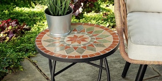 a stone tile patio table with a plant sitting on it outdoors