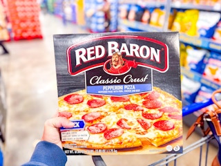 hand holding a box of red baron pizzas