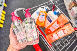 hand holding garnier face wash over a shopping cart with dial, lubriderm, and suave products