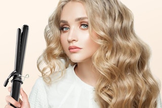 a woman holding a curling iron