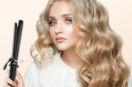 a woman holding a curling iron