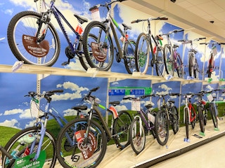 An area shot of bikes sitting on store shelves.