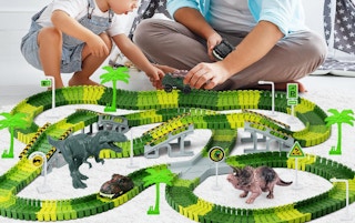 a dad and kid playing with a dinosaur racetrack 