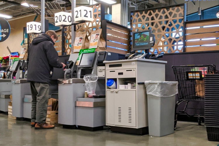 A man using a self checkout to purchase groceries