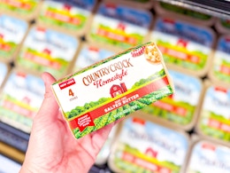 hand holding a package of Country Crock butter in front of other Country Crock butter containers