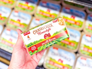 hand holding a package of Country Crock butter in front of other Country Crock butter containers