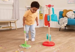 child playing with a sweep and clean plastic playset