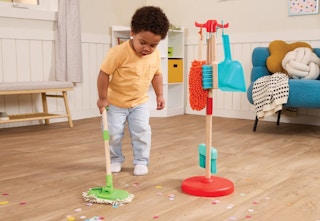 child playing with a sweep and clean plastic playset