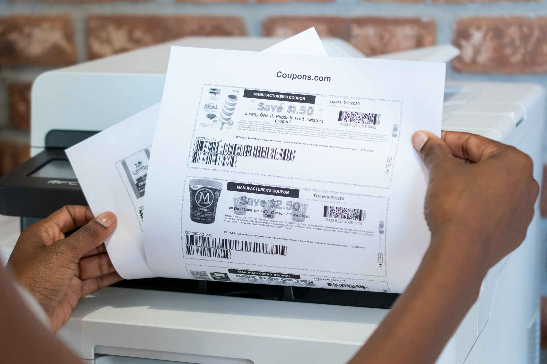 A person pulling coupons out of a printer.