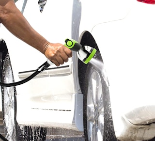 a person washing a car with a hose