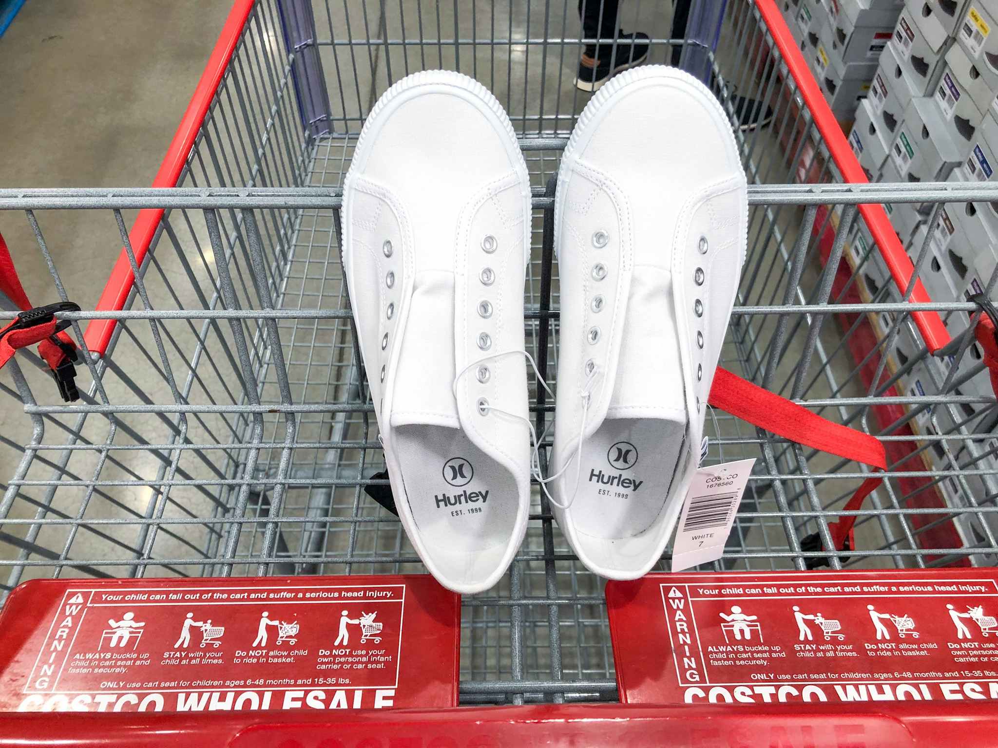 a pair of white slip on shoes in a costco cart