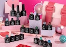 bottles of gel nail polish on a pink and white display