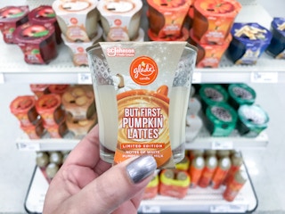 hand holding a glade pumpkin spice latte candle at target