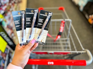 hand holding three packs of Covergirl eye pencils